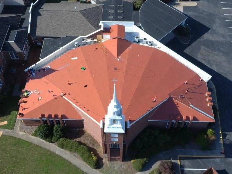 A church with a red roof and some trees